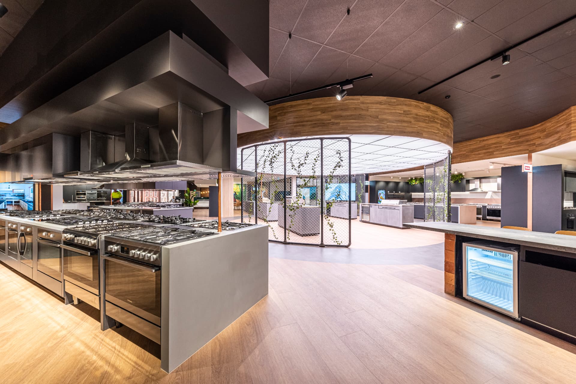 Harvey Norman showroom with kitchen displays and timber-lined ceiling